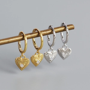 Detailed view of heart-shaped earrings with radial patterns and sparkling zircon stones