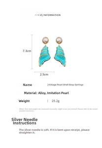 Macro view of vintage conch earrings with blue enamel, pearls and size dimensions