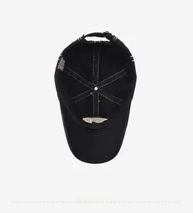 Detail view of the black cotton baseball cap interior with white stitching and brand label