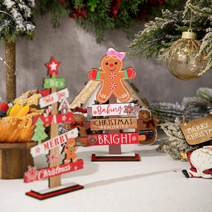 Close-up of wooden gingerbread man and Christmas tree desk ornaments with festive carvings