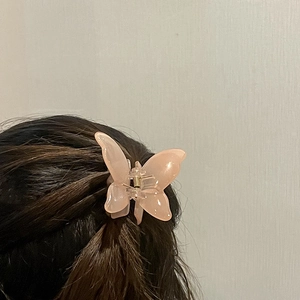 Pink translucent butterfly hair claw clip for elegant fairy hairstyle on dark brown hair