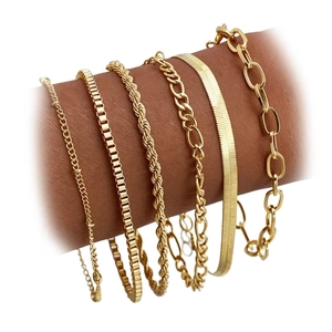 Detail eines mehrlagigen Gold-Messing-Armbandsets mit Figaro- und Schlangenketten