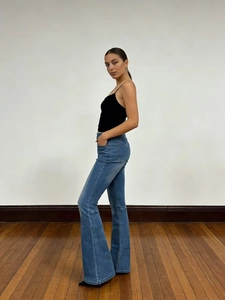 Vista laterale dei jeans svasati blu e del top nero che mostra la vestibilità aderente