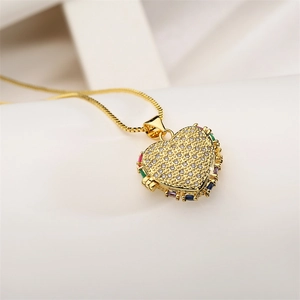 Detailed close-up of golden heart pendant featuring sparkling clear and colorful zircons