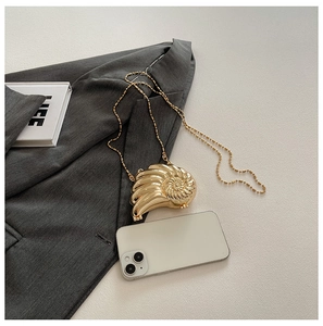 Makroaufnahme der schneckenförmigen goldenen Abendtasche mit Hochglanz-Spiralstruktur