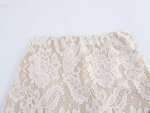 Close-up of elegant floral lace embroidery and detailed stitching on beige skirt