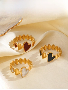 Three elegant heart-shaped enamel rings in red, black, and white on silk fabric