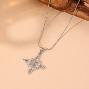 Detail of silver Celtic knot pendant with clear crystal and sleek snake chain