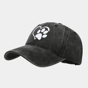 Detail view of washed cotton texture and white heart paw print on the baseball cap