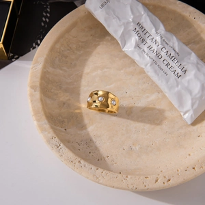 Detail of 18K gold stainless steel open ring with three pearls on a stone tray