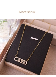 Close-up of gold titanium steel necklace with a moving zircon pavé bar pendant