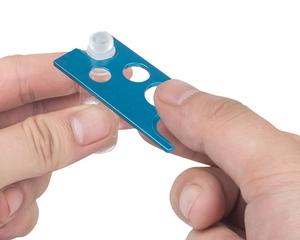 Blue metal essential oil bottle opener tool demonstrating how to remove a small roller cap