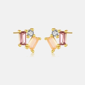 Detailed shot of gold earrings with pink and champagne stones and white zircon crystals