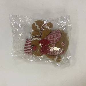 Detail of gingerbread plush toy with red plaid clothing in transparent packaging