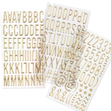 Close-up of golden metallic alphabet and number stickers for DIY creative crafts
