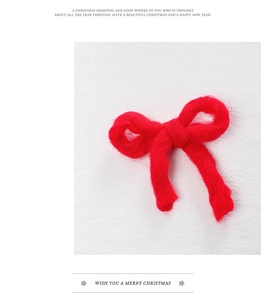 Detail view of a soft red plush bow ornament for Christmas tree festive decoration