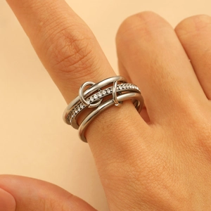 Detail view of multi-layer silver ring with pavé-set stones on woman's finger