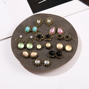 Vintage cat-eye resin and pearl earring set in various shapes on a gray display tray