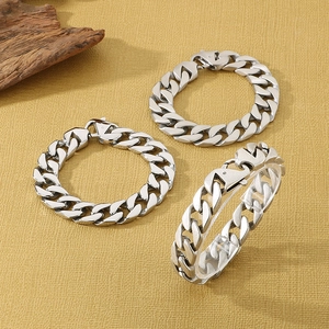 Close-up of three polished silver Cuban link bracelets with secure lobster clasps