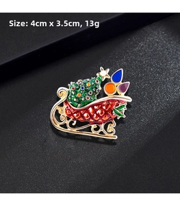 Detail of red Christmas sleigh brooch with enamel tree and gifts on black background