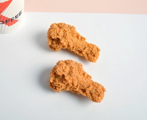 Detail of two realistic fried chicken leg models with crispy texture for food photography