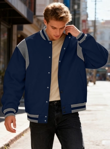 Detail of silver snap buttons and striped rib-knit cuffs on navy blue varsity jacket