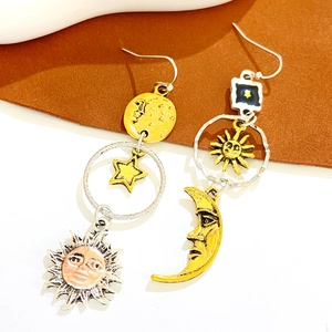 Detailed view of bohemian mismatched earrings featuring vintage sun, moon and star charms