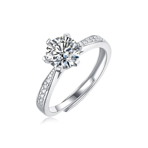 Macro shot of silver ring featuring six-prong moissanite setting and side diamond accents