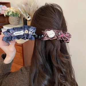 Détail d'une pince à cheveux à nœud avec ours en peluche sur une queue de cheval