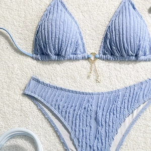 Detail of light blue textured bikini featuring starfish and pearl charm accents