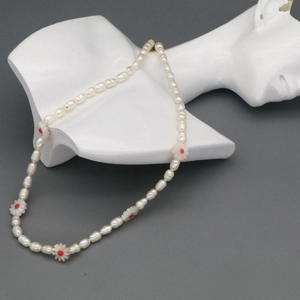 Detail of baroque pearl necklace with floral accents on a white mannequin bust