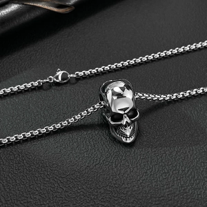 Macro shot of silver skull pendant necklace with polished square link chain