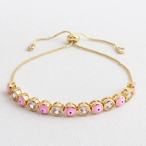 Detail of adjustable gold-plated evil eye bracelet with pink enamel and slider clasp