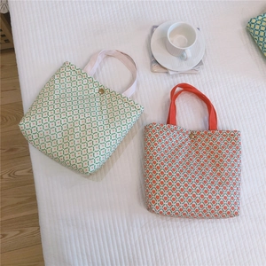Detail of floral canvas lunch bags with vintage metal snap buttons on white quilted surface