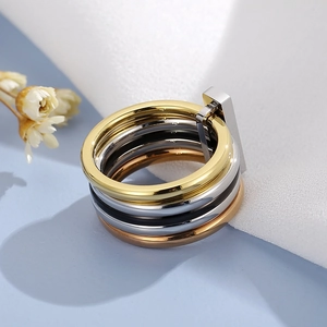 Detail showing multi-layer stacked rings in gold, silver, and rose gold with metal clasp