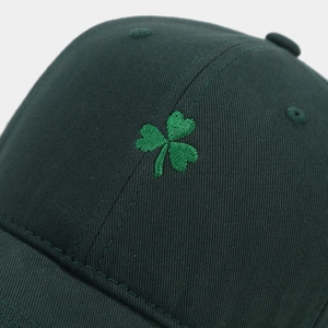 Gros plan sur la broderie de trèfle vert sur une casquette en sergé de coton vert foncé