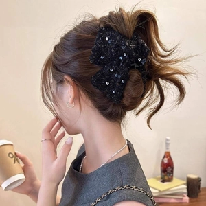 Détail macro de l'élégante pince à cheveux en sequins noirs avec texture réfléchissante