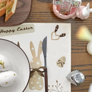 Linen Easter placemat with bunny and eggs design on a rustic wooden dining table
