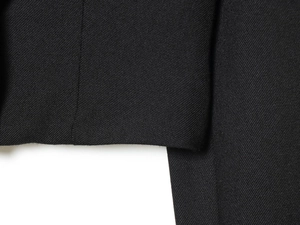 Close-up of black twill fabric texture and high-density stitching on suit jacket