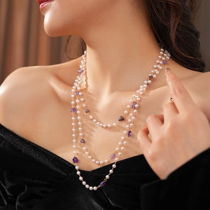 Close-up of layered necklace with white imitation pearls and purple amethyst beads
