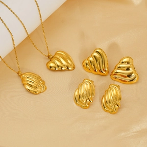 Detailed view of gold shell jewelry set with necklace, earrings and ring on silk