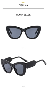 Detailed view of black cat-eye sunglasses with wide wavy temples and dark lenses