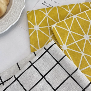 Close-up of cotton linen placemats with geometric star and black grid patterns