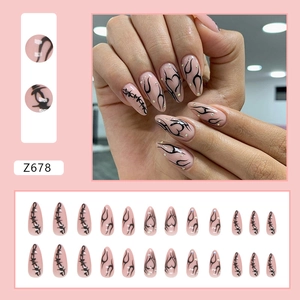 Black tribal heart almond press-on nails with rhinestones on nude pink base