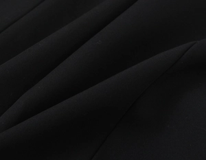 Detailed close-up of the black woven fabric texture on this women's romper garment