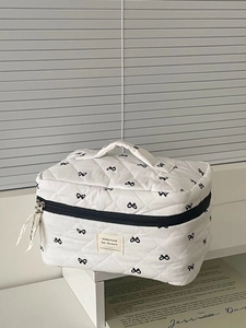 Quilted white cosmetic bag with black bows, top handle and large capacity storage
