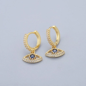 Close-up of golden evil eye hoop earring with blue stone and pavé zircon details