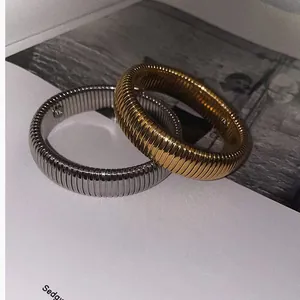Primo piano di bracciali Tubogas in oro e argento con trama metallica a costine
