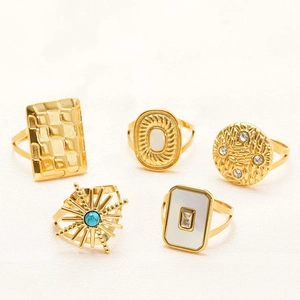 Ensemble de cinq bagues dorées avec détails turquoise, nacre et zircone