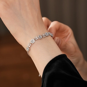 Détail d'un bracelet en argent avec pierre œil-de-chat verte et zircon sur le poignet
